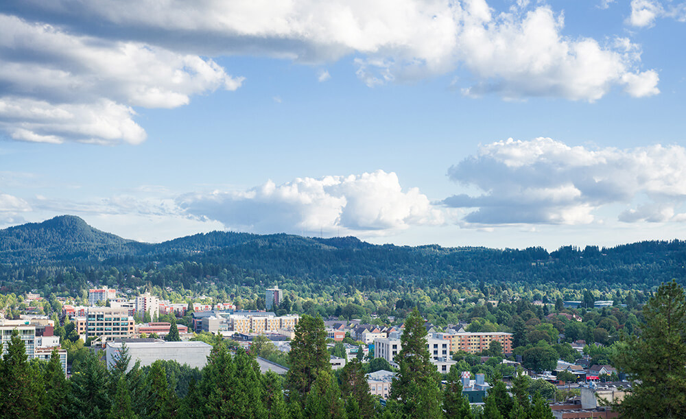 Eugene, Oregon skyline under a blue summer sky dotted with clouds taken from Skinner's Butte.