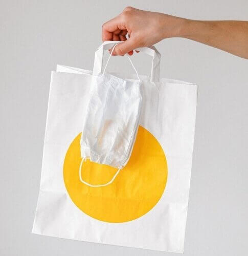 Person Holding Takeout Bag and Face Mask