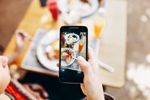 Person Holding Phone Taking Picture of Brunch Order