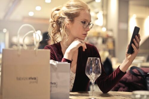 Woman Using Phone at Restaurant